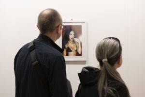 Visitatori a Lucca Art Fair, edizione 2024, che osservano “Megan Fox” (2010) di Terry Richardson. Ph Tiziano Rossano Mainieri, courtesy Lucca Art Fair