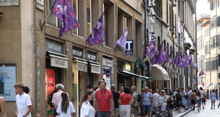 Bandiere viola della Fiorentina 1926-2026 appese in via Guicciardini, nel centro di Firenze, per il centenario.