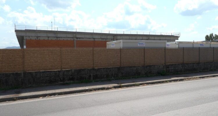Cantiere di Salanetti con recinzione in pannelli e edificio industriale in costruzione