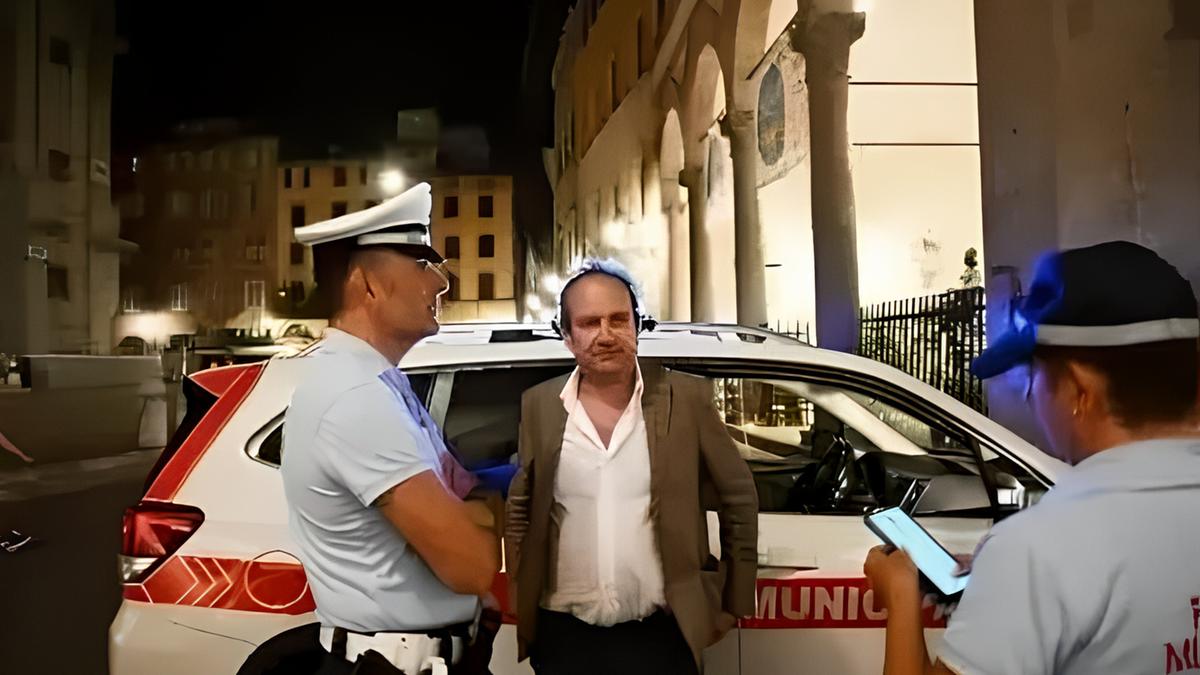 Agenti della Polizia Municipale di Lucca durante un controllo notturno accanto all’auto di pattuglia