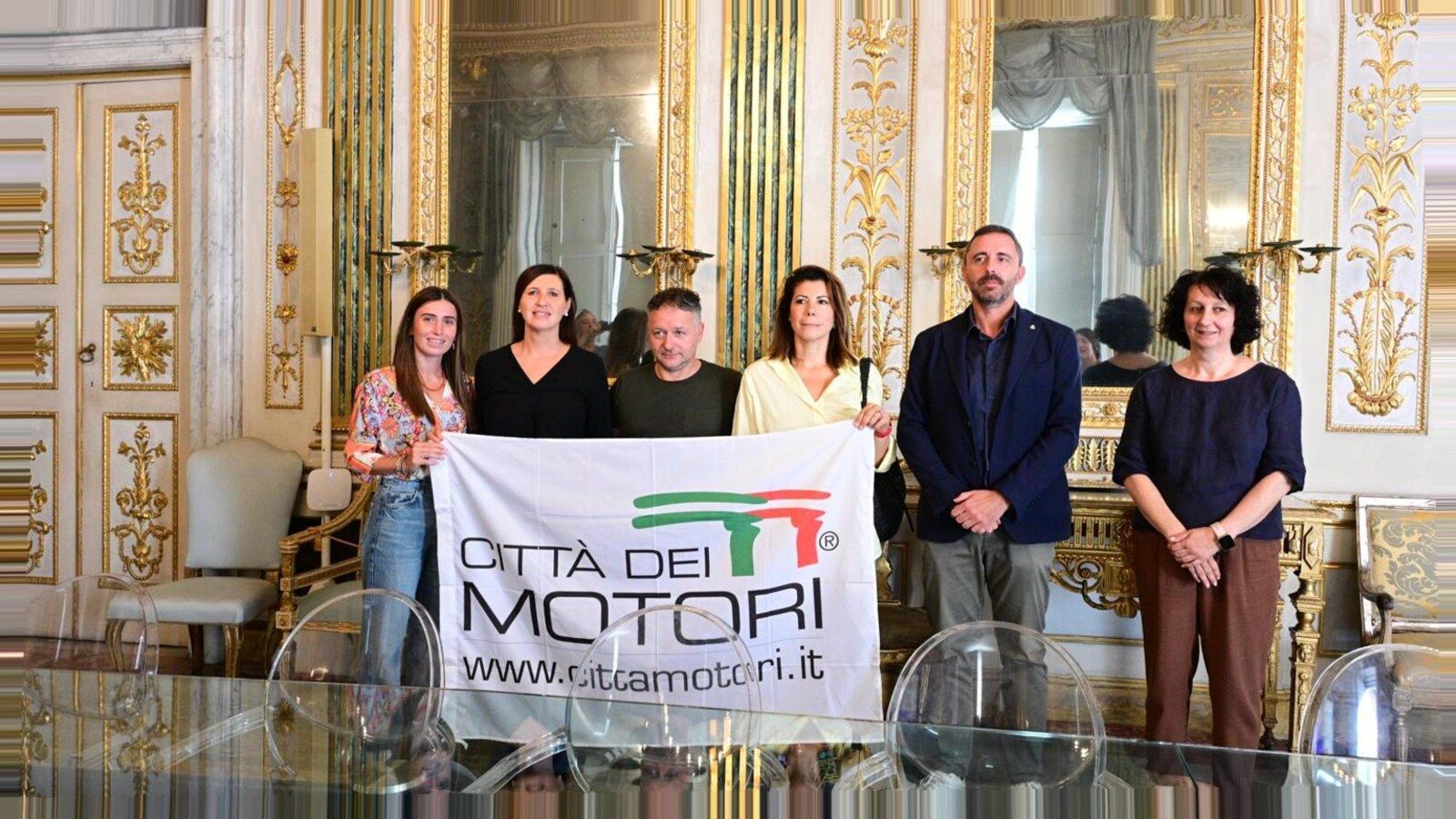 Presentazione Italian Motor Week 2026 a Lucca — stessi soggetti, nuova angolazione e inquadratura (nessun volto alterato)