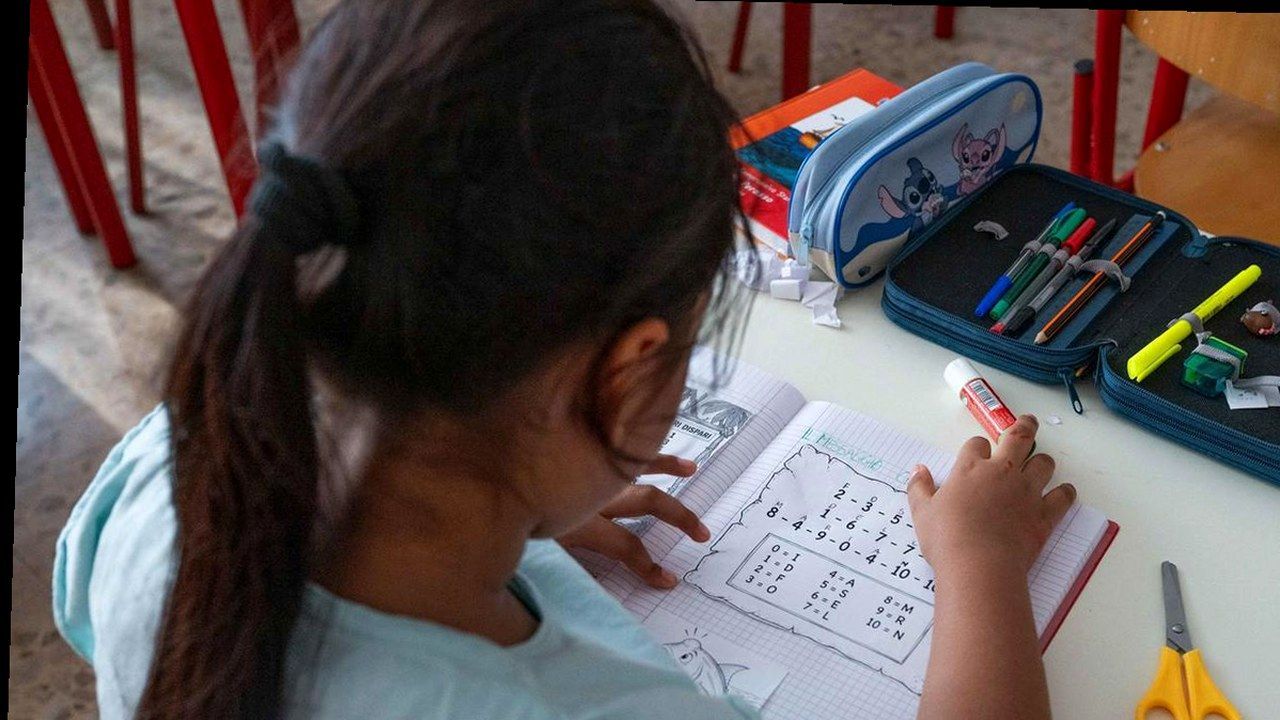 Scrivania di scuola con quaderno, colla stick e astuccio visti dall'alto: il bando Libri Gratis per i libri scolastici