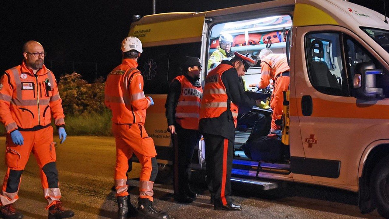 Soccorritori del 118 e carabinieri accanto a un'ambulanza durante un intervento notturno