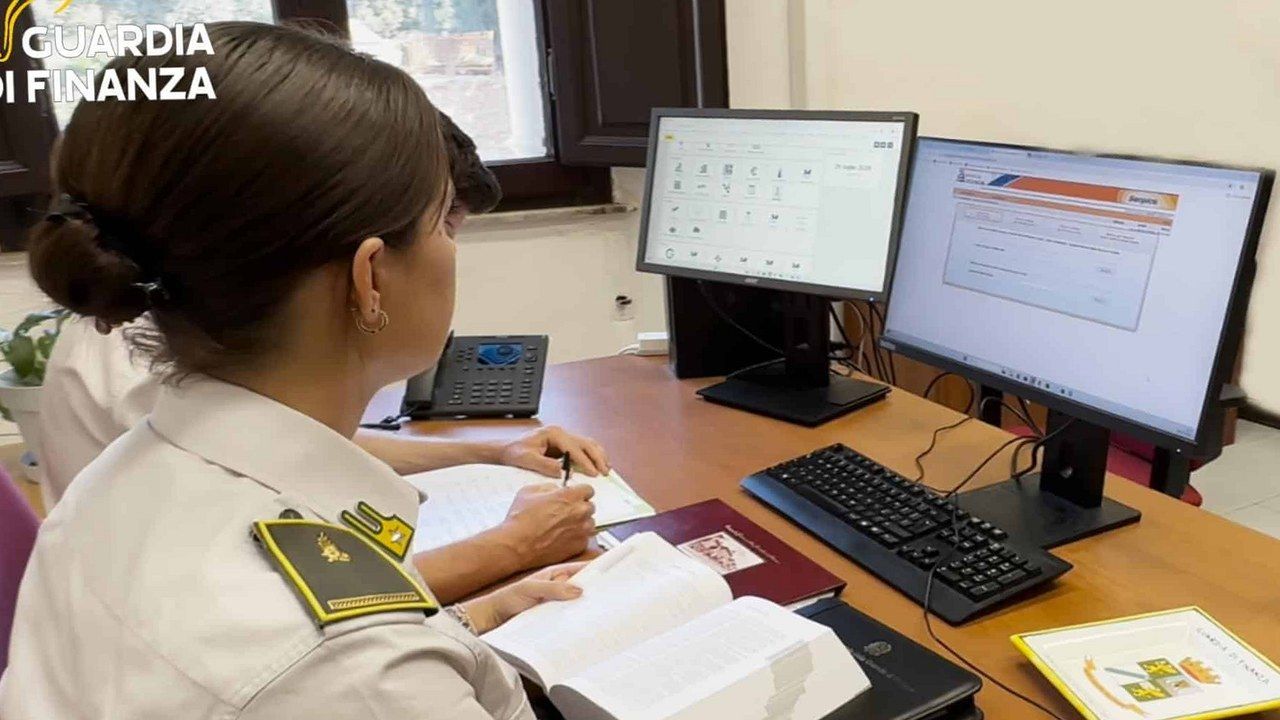 Lucca, militare della Guardia di Finanza al lavoro su documenti contabili durante un controllo fiscale