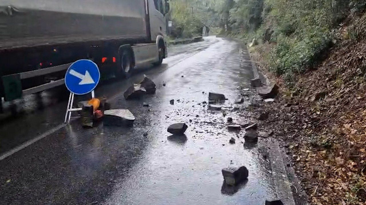 Massi e detriti caduti sull'asfalto bagnato della via delle Cartiere, poco sopra Collodi, accanto a un segnale di deviazione e a un tir in transito