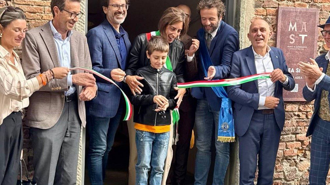 Taglio del nastro del Mast ad Altopascio in piazza Ospitalieri: targa del museo e autorità con fascia tricolore — angolazione geometrica modificata, senza alterazione di volti