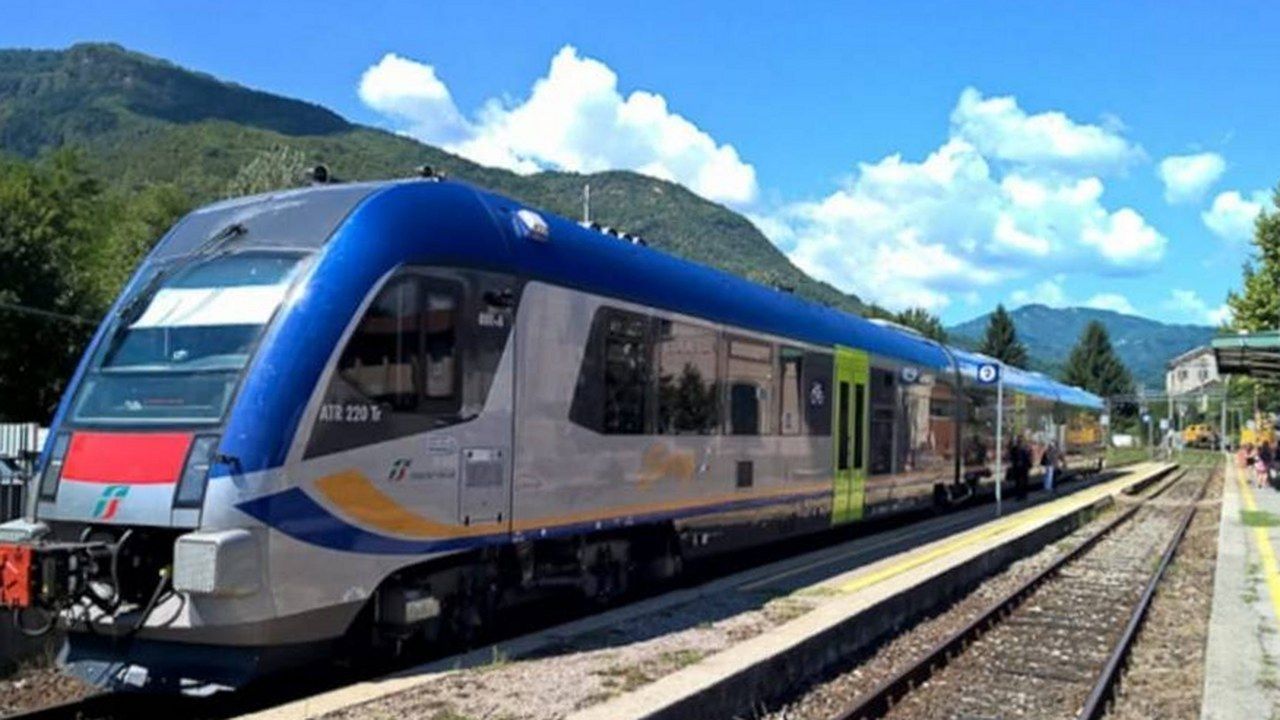 Un treno regionale fermo al binario di una stazione della linea Lucca-Aulla