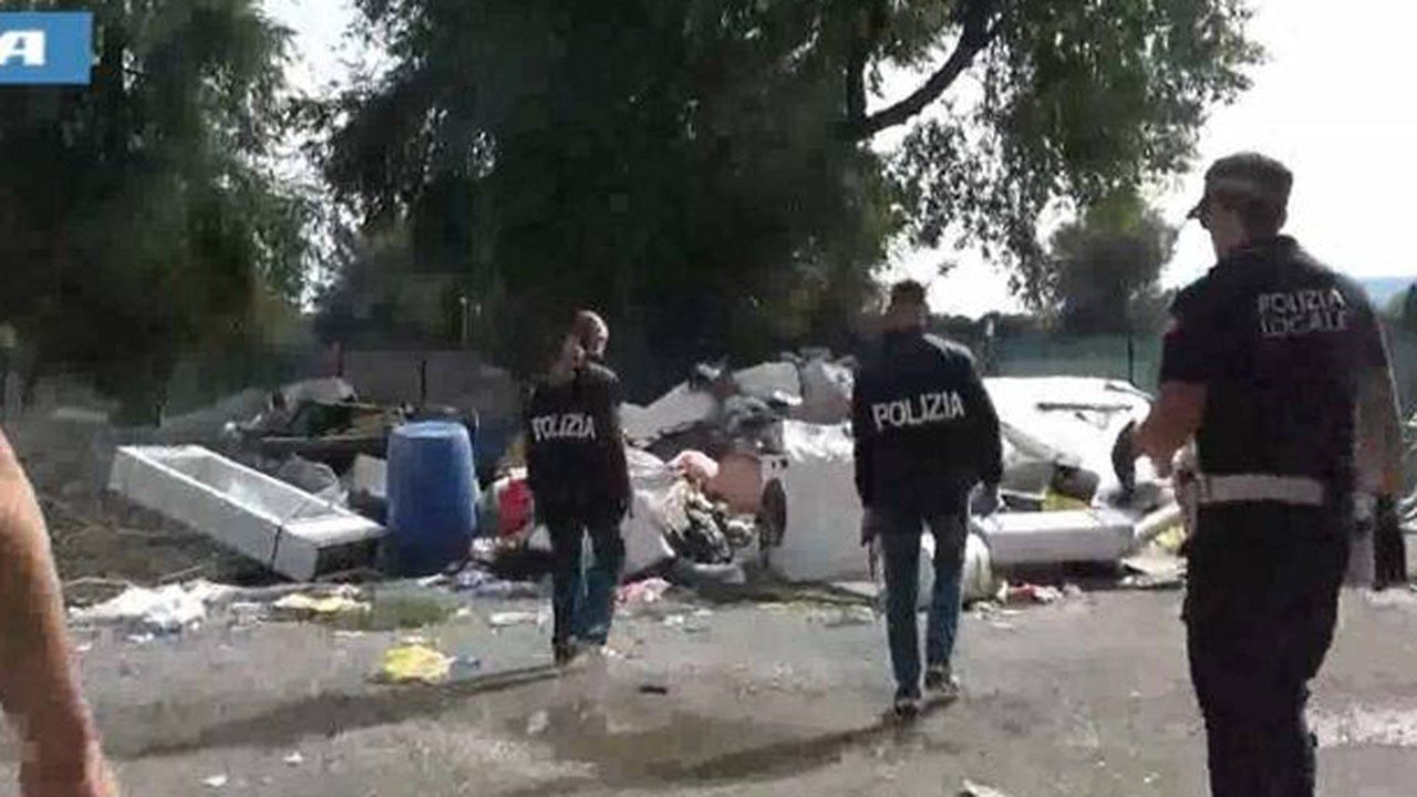Agenti della Polizia di Stato e della Polizia Locale tra i cumuli di rifiuti nell'area dell'ex campo nomadi delle Tagliate a Lucca