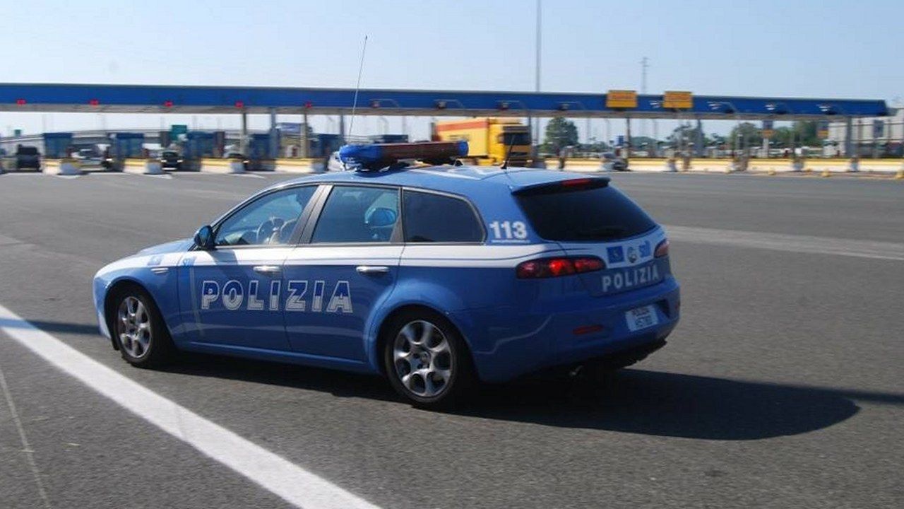 Auto della Polizia di Stato davanti a un casello autostradale, immagine di repertorio