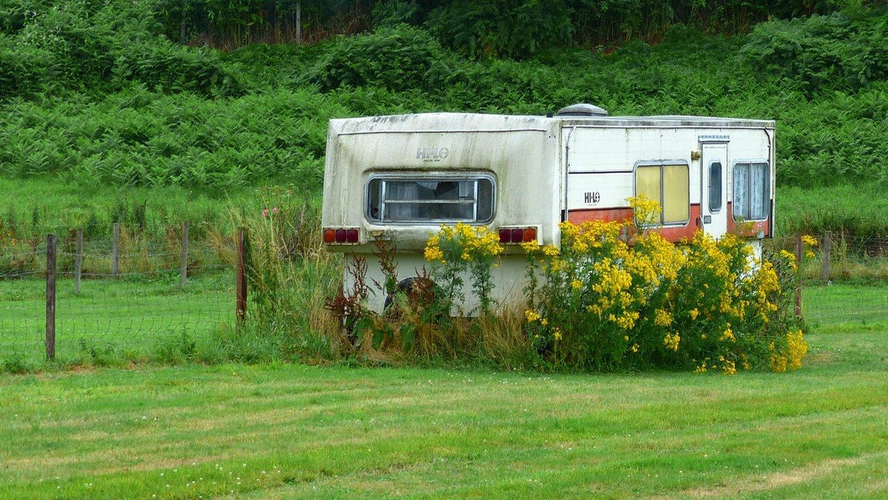 Una vecchia roulotte parcheggiata nell'erba (foto di repertorio)