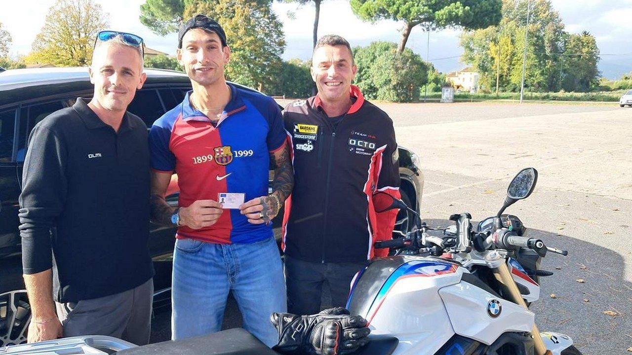 Samuele Salvatori con la patente speciale per moto insieme a Luca Olmi ed Emiliano Malagoli, accanto alla moto dell'esame