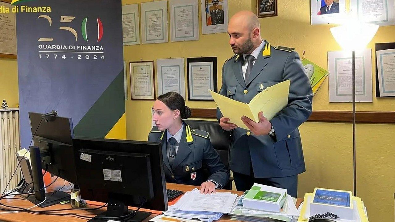 Guardia di Finanza al lavoro su documenti fiscali in un ufficio
