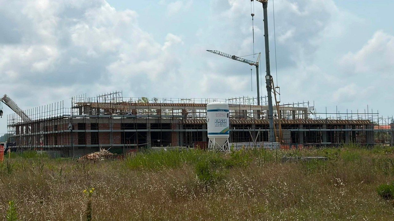 Il cantiere della nuova piscina comunale di via delle Darsene a Viareggio, con gru e impalcature — angolazione e inquadratura rielaborate