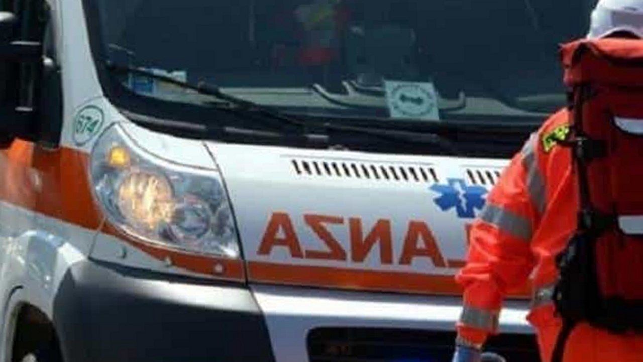Un'ambulanza del 118 con un soccorritore in divisa arancione, immagine di repertorio — angolazione e inquadratura rielaborate