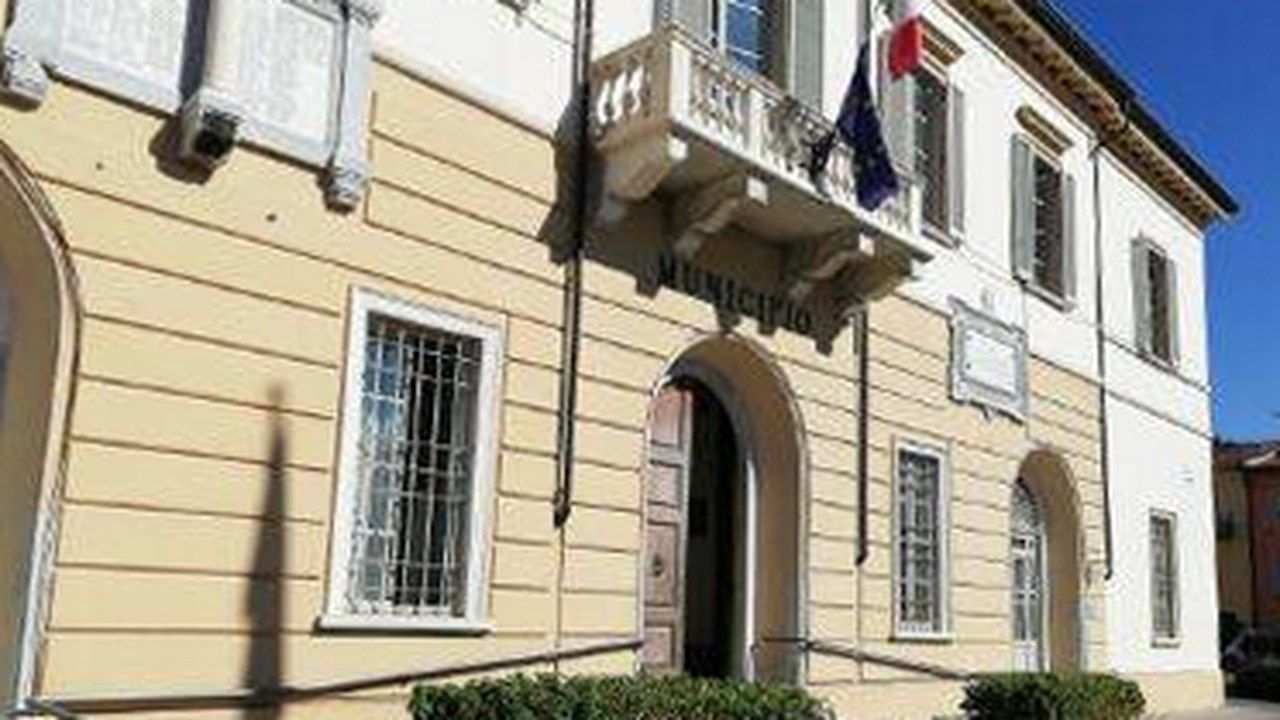 Il palazzo comunale di Massarosa con le bandiere sul balcone — angolazione e inquadratura rielaborate